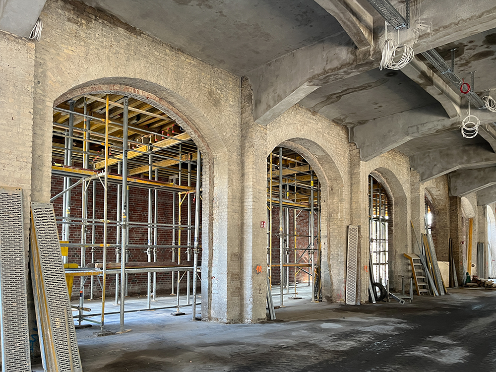 Baufortschritt der Büros im Postbahnhof Berlin mit Gerüst und offenen Bögen.