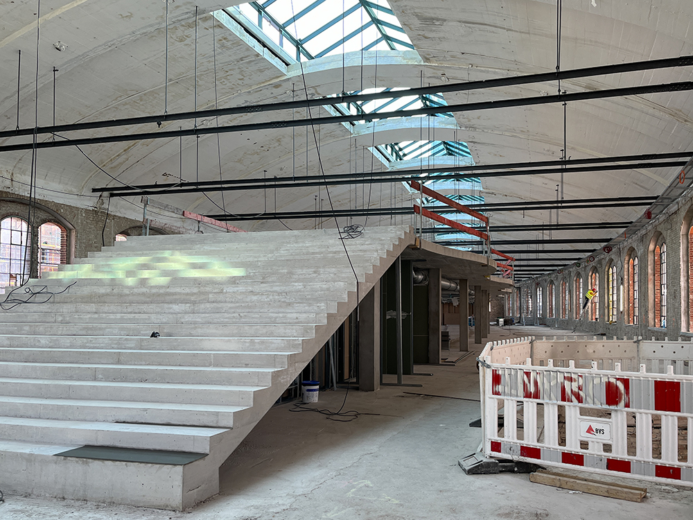 Baufortschritt der Büros im Postbahnhof Berlin mit Betonstufen und großen Fenstern.