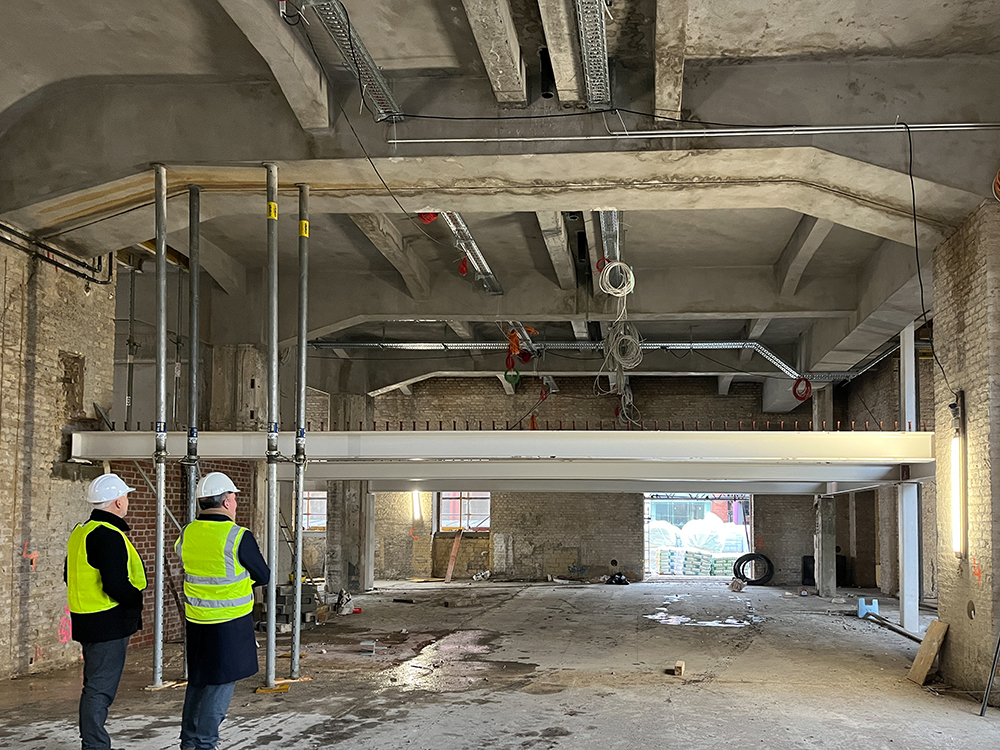 Baufortschritt der Büros im Postbahnhof Berlin mit Bauarbeitern und Rohbau