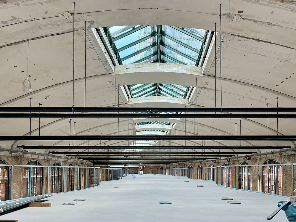 Fortschritt beim Bau der Büros im Postbahnhof Berlin, mit Betonboden und Stahlkonstruktion.