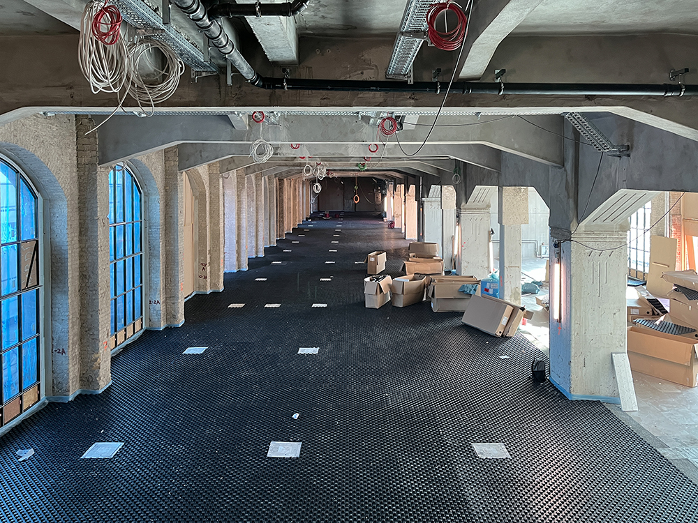 Fortschritt der Bauarbeiten im Postbahnhof Berlin mit Kisten und Baustellenmaterial.