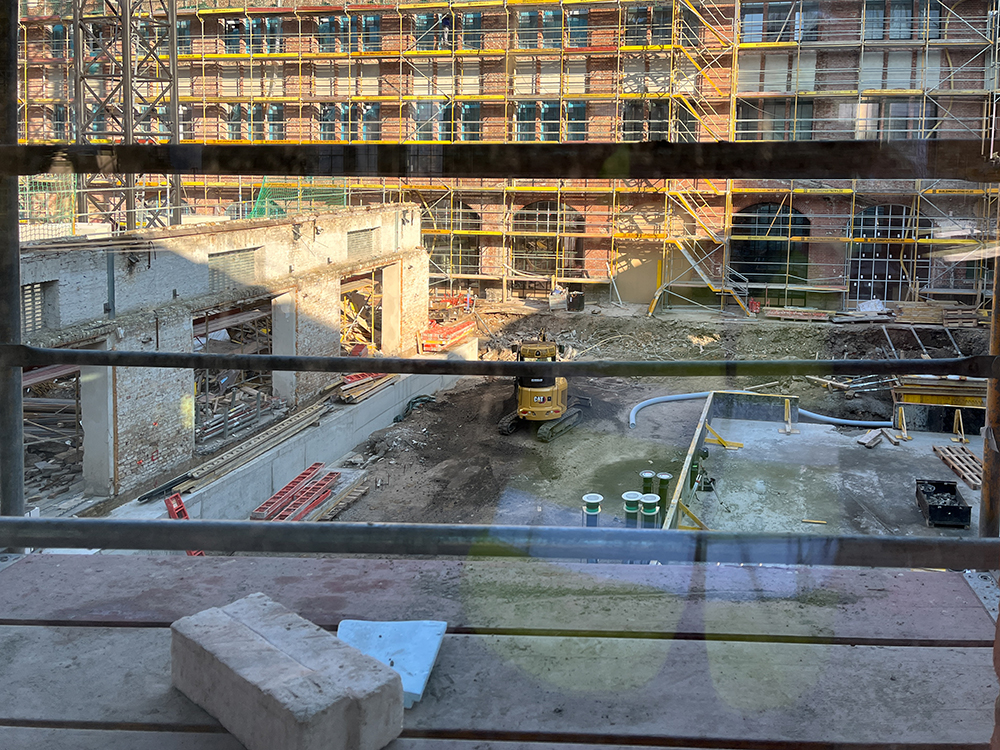 Baufortschritt der Büros im Postbahnhof Berlin, Baustelle mit Gerüst und Maschinen.