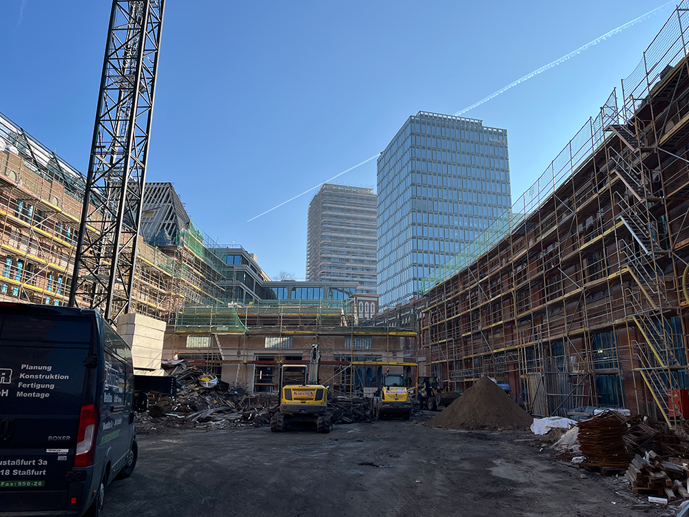Fortschritt der Bauarbeiten an den Büros im Postbahnhof Berlin unter blauem Himmel.
