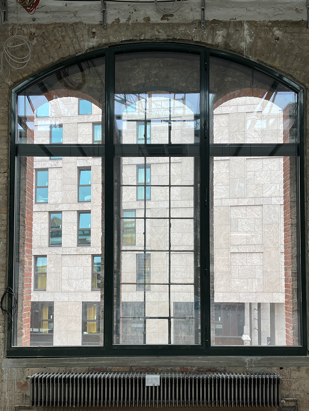 Innenansicht des Postbahnhofs mit großen Fenstern und Heizkörper